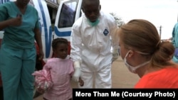 More Than Me’s focus temporarily shifted from education to emergency health care as the Eboloa crisis peaked in Liberia. A health worker and Katie Meyler, crouching, reassure a young girl in Monrovia.