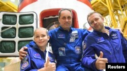 Bemanningsleden, kosmonaut Anton Shkaplerov, actrice Yulia Peresild en filmregisseur Klim Shipenko.