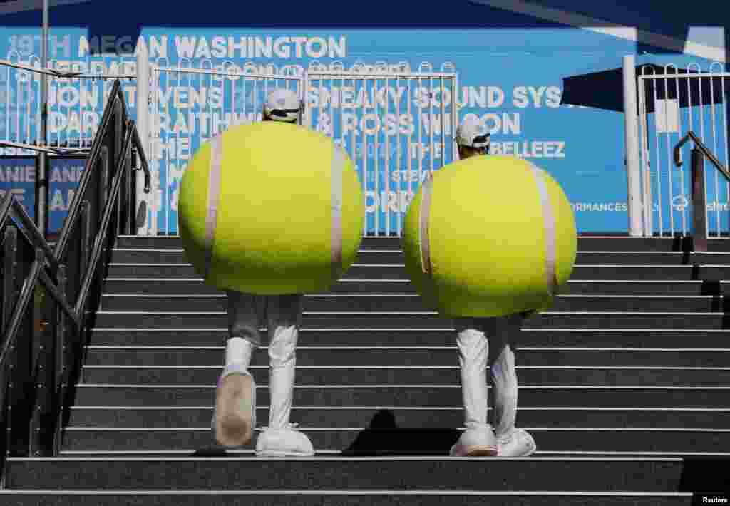 Entertainers dressed in outfits shaped like tennis balls walk around the Rod Laver Arena at the Australian Open 2015 tennis tournament in Melbourne.