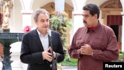 FILE - Former Spanish prime minister Jose Luis Rodriguez Zapatero, left, talks next to Venezuela's President Nicolas Maduro after their meeting at Miraflores Palace, in Caracas, Venezuela, Nov. 23, 2016.