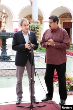 Former Spanish prime minister Jose Luis Rodriguez Zapatero, left, talks next to Venezuela's President Nicolas Maduro after their meeting at Miraflores Palace, in Caracas, Venezuela, Nov. 23, 2016.