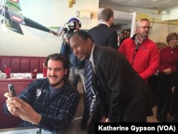 Republican presidential candidate Ben Carson takes a photo with a diner at the Airport Diner in Manchester, New Hampshire, Feb. 7, 2016.