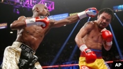 Manny Pacquiao (kanan) dalam pertarungan dengan Floy Mayweather, Sabtu (2/5) di Las Vegas. (AP/John Locher)