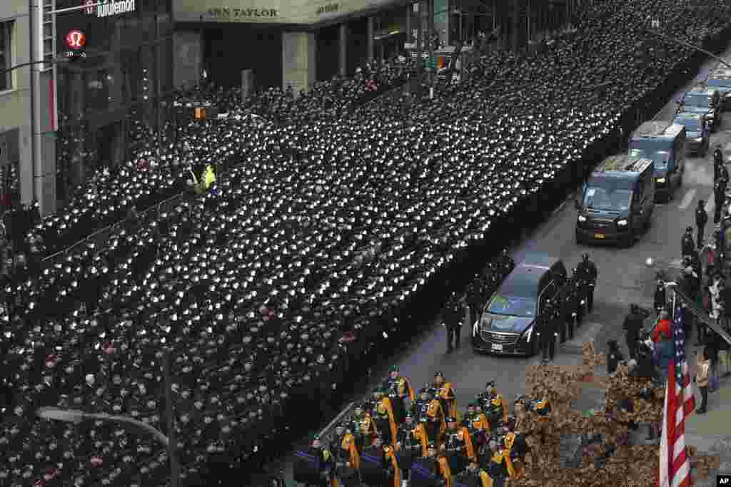 New York Police salute as a hearse carrying the casket of NYPD Officer Wilbert Mora is escorted down Fifth Avenue after his funeral service at St. Patrick&#39;s Cathedral in New York.&nbsp;Mora was shot along with Officer Jason Rivera on Jan. 22 while responding to a call about a domestic argument in an apartment.