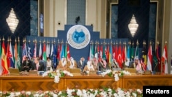 Emir Kowet la, Sheikh Sabah al-Ahmed al-Sabah (nan mitan), Sekretè Jeneral l'ONU an, Ban Ki-moon (agoch) ak Minis Afè Etranjè Kowet la, Sheikh Sabah Khalid al-Hamad al-Sabah (adwat) nan seremoni ouvèti Konferans Donatè yo ap fè sou Siri nan Grann Sal Palè Liberasyon Bayan nan, nan Kowet.