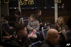 Noor, 8 (C) sits with her sister Maryam, 18, and their mother Nadia Hanan Madalo, 46 (R) as they wait in an airport bus in Irbil, Iraq, March 15, 2017. An Iraqi family has landed in the United States as a federal court blocked a travel ban that would have