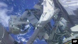 A frame from NASA TV, NASA shows astronaut Ricky Arnold (L) and NASA astronaut Drew Feustel shuffling around a couple of space station pumps at the International Space Station on May 16, 2018.