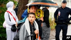 Seorang dari kelompok Roma, atau Gipsi, berargumen dengan polisi Perancis di tengah penggusuran kamp mereka di La Courneuve, pinggir kota Paris (27/8). (AP/Francois Mori)