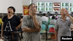 在武汉的证券交易市场，股民们看着电脑屏幕上的股市行情（2015年7月3日）