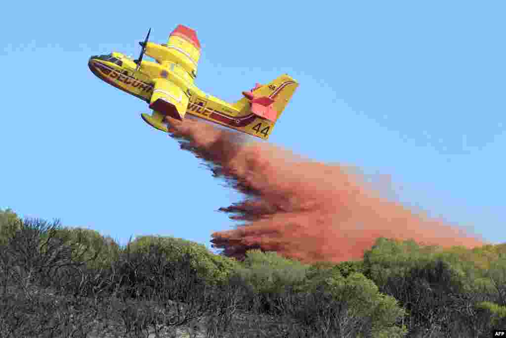 A Canadair fire-fighting aircraft drops a substance used to put out fire, in Ajaccio, France.
