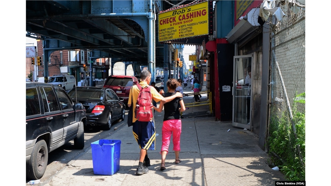After using heroin, a young white couple struggles to make it down the street.