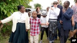 U.S. performer Madonna tours Mphandura orpahange with her two adopted children David Banda, second from left, and Mercy James, third from left, near Lilongwe, Malawi, April 5, 2013.