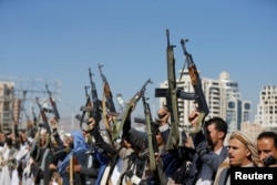 Armed Houthi followers raise their rifles at a gathering showing support for their movement in Sanaa, Yemen, Dec. 19, 2018.