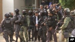 Dalam rekaman gambar video memperlihatkan Damaso Lopez atau lebih dikenal dengan "El Licenciado," dikawal polisi setelah ditangkap di sebuah apartemen di Mexico City. (Foto:dok)