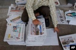 FILE - A Bangladeshi worker classifies newspapers, in Dhaka, Bangladesh, Feb. 20, 2016. Under Section 57 of Bangladesh’s Information and Communications Technology Act, journalists can be jailed for a variety of offenses, such as defamation, hurting relig