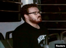 FILE - Rurik George Caton Jutting sitting in the back row of a prison bus as he arrives at the Eastern Law Courts in Hong Kong. November 24, 2014