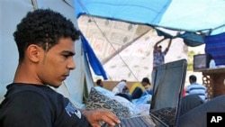 A Bahraini anti-government protester works on his computer in a tent at Pearl roundabout in Manama, Bahrain, February 28, 2011