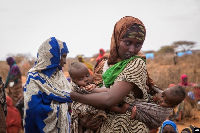 FILE - Basherow Hassen, a mother of four, waits for food aid with her twin children in the Warder district in the Somali region of Ethiopia, Jan. 28 2017.