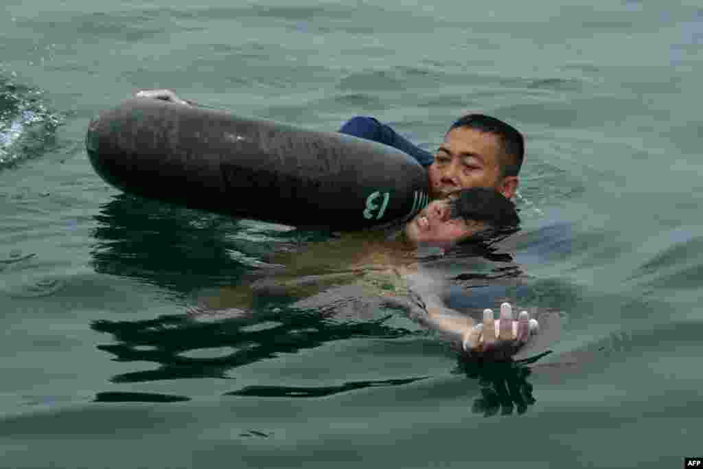 In this handout photograph released by the Indonesian Navy, a Navy diver rescues helicopter crash survivor Fransiskus Subihardayan after he was found by the search and rescue team in Lake Toba, western Sumatra island.&nbsp; Fransiskus Subihardayan floating naked in a huge volcanic lake two days after the helicopter he was travelling in is believed to have crashed into the waters, officials said.