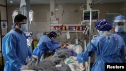 Enfermeras con trajes de protección preparan a un paciente con COVID-19 para transferirlo al Hospital Masih Daneshvari, en Teherán, el 30 de marzo de 2020.