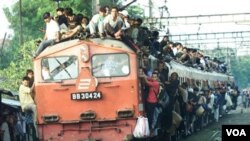 Penumpang bergelantungan di salah satu kereta api yang bergerak keluar dari stasiun Tanah Abang, Jakarta pada saat mudik lebaran (foto: dok).