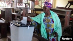 A woman casts her ballot at a polling station in Guinea's capital Conakry, Sept. 28, 2013. 