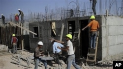 Palestinian men work on a construction site in the West Bank Jewish settlement of Kiryat Arba, near Hebron, 20 Oct 2010