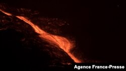 The lava flow of the Cumbre Vieja volcano is pictured from Los Llanos de Aridane on the Canary Island of La Palma at night, Oct. 8, 2021.