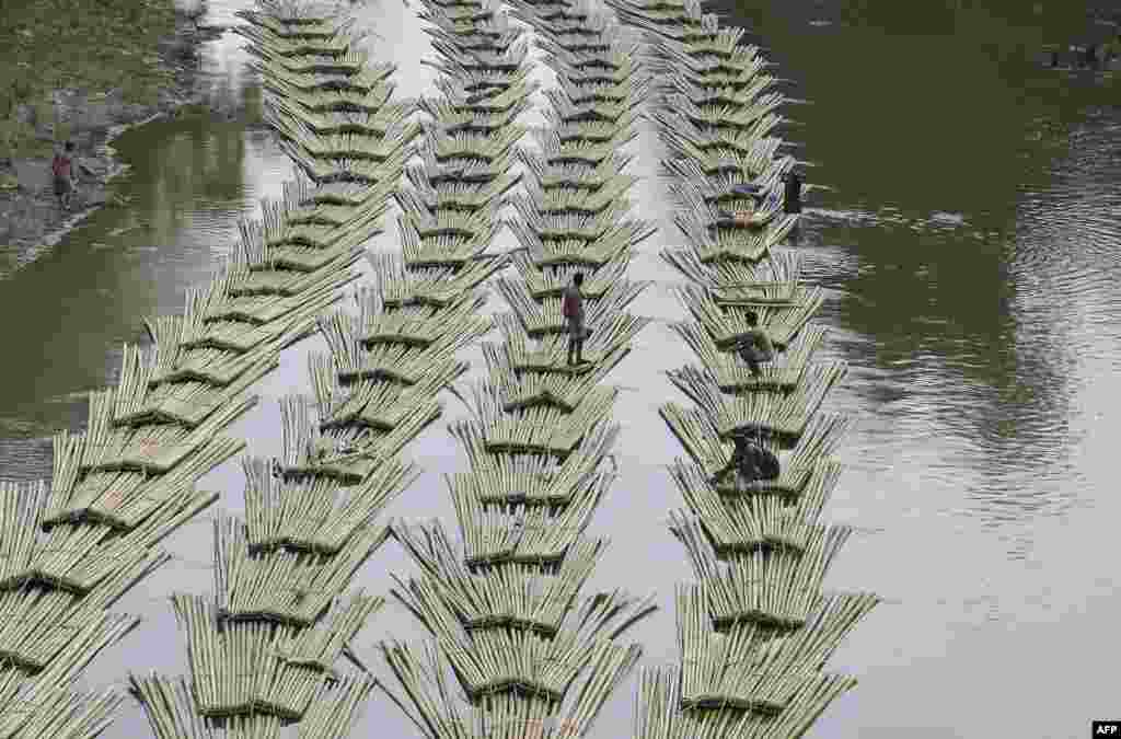 Indian laborers transport bamboo logs down the Longai River near the Tripura-Mizoram state border in Damchara, April 18, 2017.