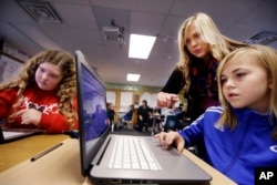 FILE: Computer science teacher Sheena York, center, helps fifth grade students work on programming during their weekly computer science lesson at Marshall Elementary School in Marysville, Wash. Photo taken Nov. 4, 2015 (AP Photo/Elaine Thompson)