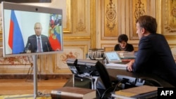 Президент Франции Эмманюэль Макрон проводит беседу по видеосвязи из Елисейского дворца с президентом РФ Владимиром Путиным, 26 июня 2020 г. (фото by Michel Euler / POOL / AFP) 