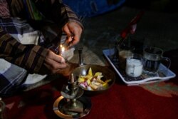 Pawang hujan Ki Joko Sapu Jagat, menyalakan dupa sebagai bagian ritual menjelang pelaksanaan sebuah perhelatan di Bekasi, 16 Oktober 2021. (REUTERS/Ajeng Dinar Ulfiana)