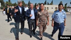 U.S. Secretary of State John Kerry (L) and Jordanian Foreign Minister Nasser Judeh (2nd L) are escorted by military officers to a helicopter bound for Zaatari refugee camp, at Marka airport in Amman, July 18, 2013.