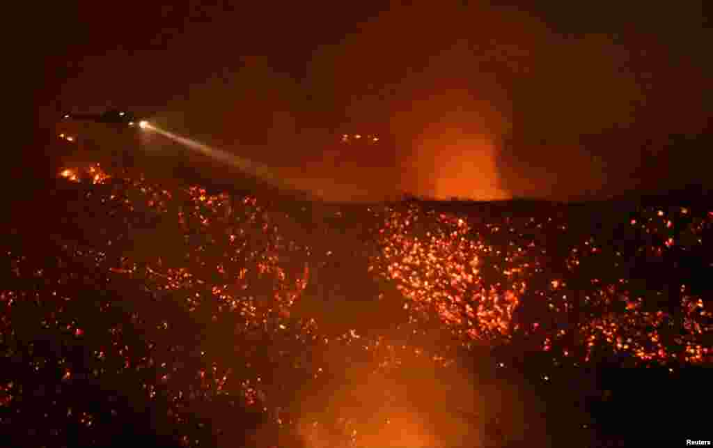미국 캘리포니아주 칼라바사스 지역에 발생한 &#39;올드파이어&#39; 산불 현장에 4일 헬리콥터가 물을 뿌리고 있다.