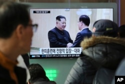 People watch a TV screen showing North Korean leader Kim Jong Un, left, meeting with South Korean National Security Director Chung Eui-yong in Pyongyang, North Korea, at the Seoul Railway Station in Seoul, South Korea, March 7, 2018.