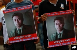 People carry portraits of student activist Nazimuddin Samad as they attend a rally to demand arrest of three motorcycle-riding assailants who hacked and shot Samad to death, in Dhaka, Bangladesh, April 8, 2016.