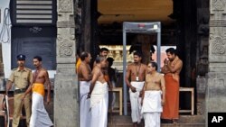 A policeman stands guard as temple staff crowd at the north side entrance of the 16th century Sree Padmanabhaswamy Temple in Trivandrum, India, July 6, 2011