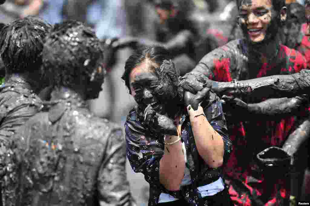 People smear plant ash onto each other during &quot;Monihei Carnival&quot;, in Cangyuan, Yunnan province, China, April 30, 2017.