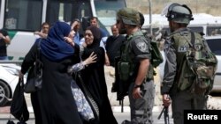 Seorang perempuan berdebat dengan polisi di dekat lokasi tertembaknya dua warga Palestina dekat pos penjagaan Qalandia, Ramallah, Tepi Barat (27/4).