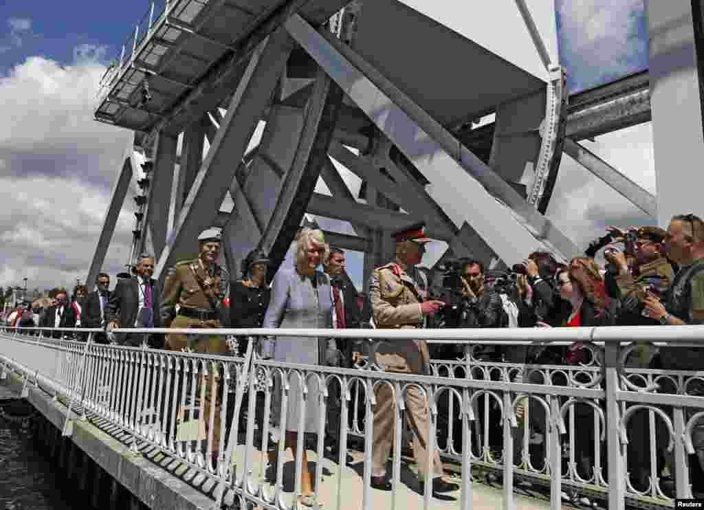 Britain&#39;s Prince Charles crosses the rebuilt Pegasus bridge with his wife Camilla, Duchess of Cornwall, in Benouville, France, June 5, 2014.