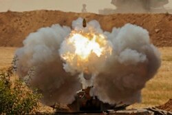 Israeli soldiers fire a 155mm self-propelled howitzer towards the Gaza Strip from their position along the border in the southern Israeli city of Sderot.