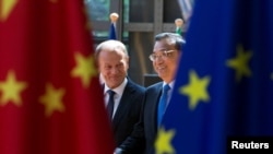FILE - European Council President Donald Tusk and Chinese Premier Li Keqiang arrive to attend an EU-China Summit in Brussels, Belgium, June 2, 2017.