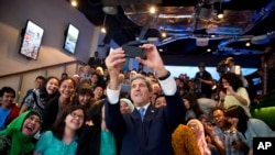 Secretary of State John Kerry takes a selfie with a group of students before delivering a speech on climate change on Sunday, Feb. 16, 2014, in Jakarta.