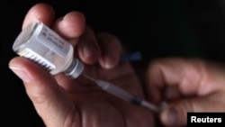 A nurse prepares a H1N1 influenza vaccine during the start of a campaign against the influenza at a hospital in Tegucigalpa March 23, 2010. There have been 18 deaths since the arrival of the virus in the country, according to Honduras Ministry of Health. 