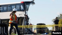 An official takes pictures at the scene of the accident involving a bus and a train, Ottawa, September 18, 2013.