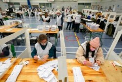 Election staff sort votes during the count for the North Shropshire by-election in Shrewsbury, England, Dec. 17, 2021.