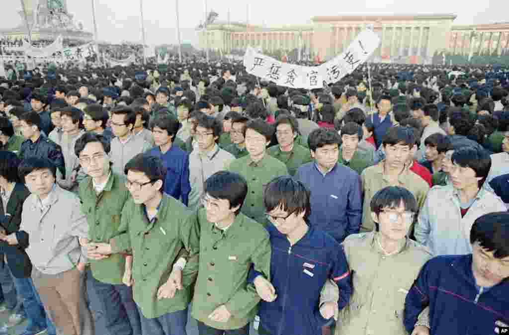 Chinese students link arms in solidarity at dawn in Tiananmen Square in Beijing, April 22, 1989. 