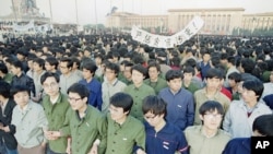 1989年4月22日，中国学生清晨在天安门广场手挽着手团结一致。