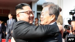 O presidente sul coreano Moon Jae-in (à direita) abraça o lider norte coreano Kim Jong hoje 