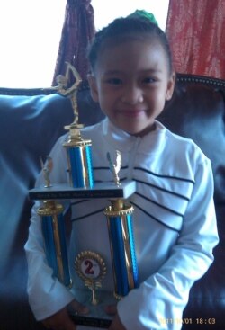 Sunisa Lee, at the age of 7, with her first trophy. (Courtesy of Lee's family)